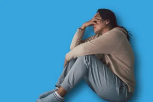 une femme assise le visage dans les mains en quête d'aide pour savoir quoi faire afin de venir à bout de sa dépression