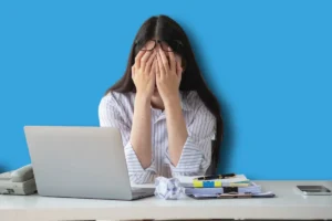 une femme en plein burn out, la tête dans les mains, au bord des larmes. Elle ne sait pas qu'elle peut bénéficier d'un arrêt de travail pour burn out