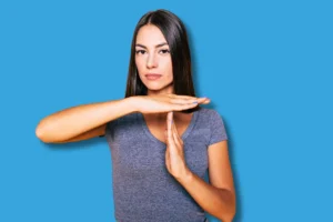 Une femme qui fait STOP de la main pour signifier qu'elle arrête de travailler