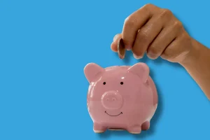 une personne qui rempli une tirelire pour illustrer le sujet de l'article qui porte sur le financement de son bilan de compétences à Fécamp