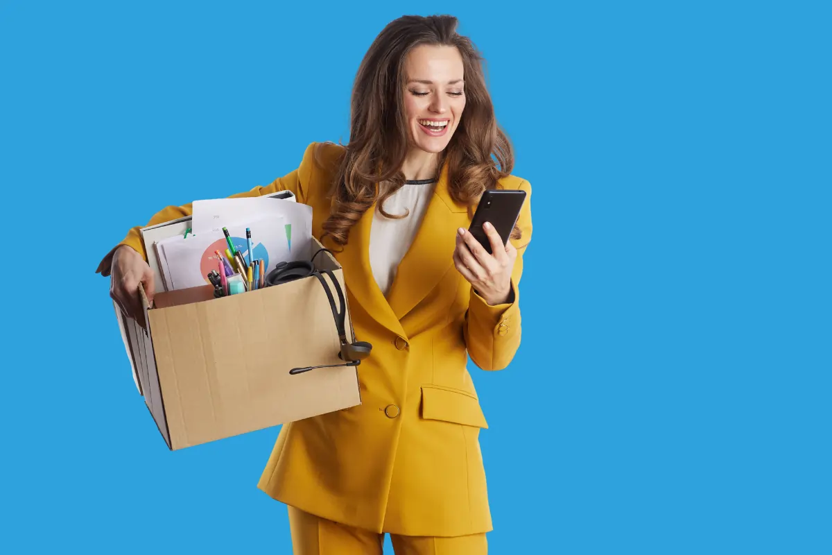 Une femme professionnelle avec ses affaires de bureau qui a le sourire quand elle apprend qu'elle peut bénéficier d'aides de la région pays de la loire pour faire sa transition professionnelle