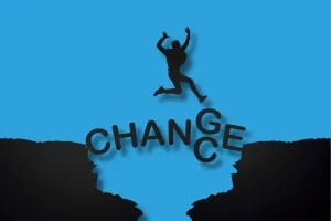 un homme qui saut d'un ravin à l'autre avec le mot "change" écrit pour montrer que prendre des risques ça aide à avancer, comme les reconversion à Cholet