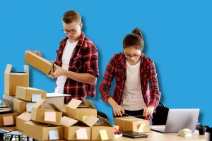 Deux persoonnes, un homme et une femme qui emballent des cartons pour leur PME nantaise