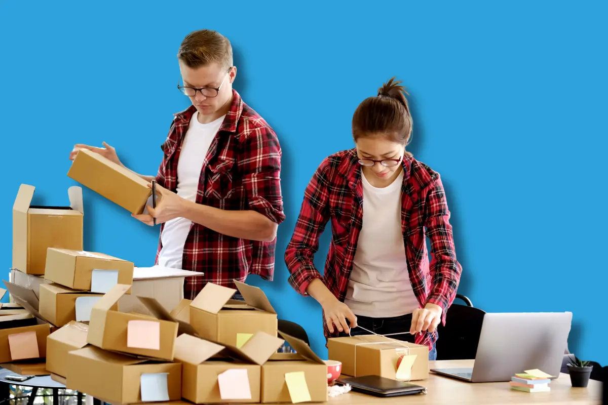 Deux persoonnes, un homme et une femme qui emballent des cartons pour leur PME nantaise