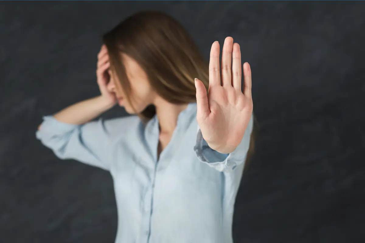 une femme qui montre la paume de sa main pour exprimer qu'elle apprend à dire non suite à son retour de longue maladie