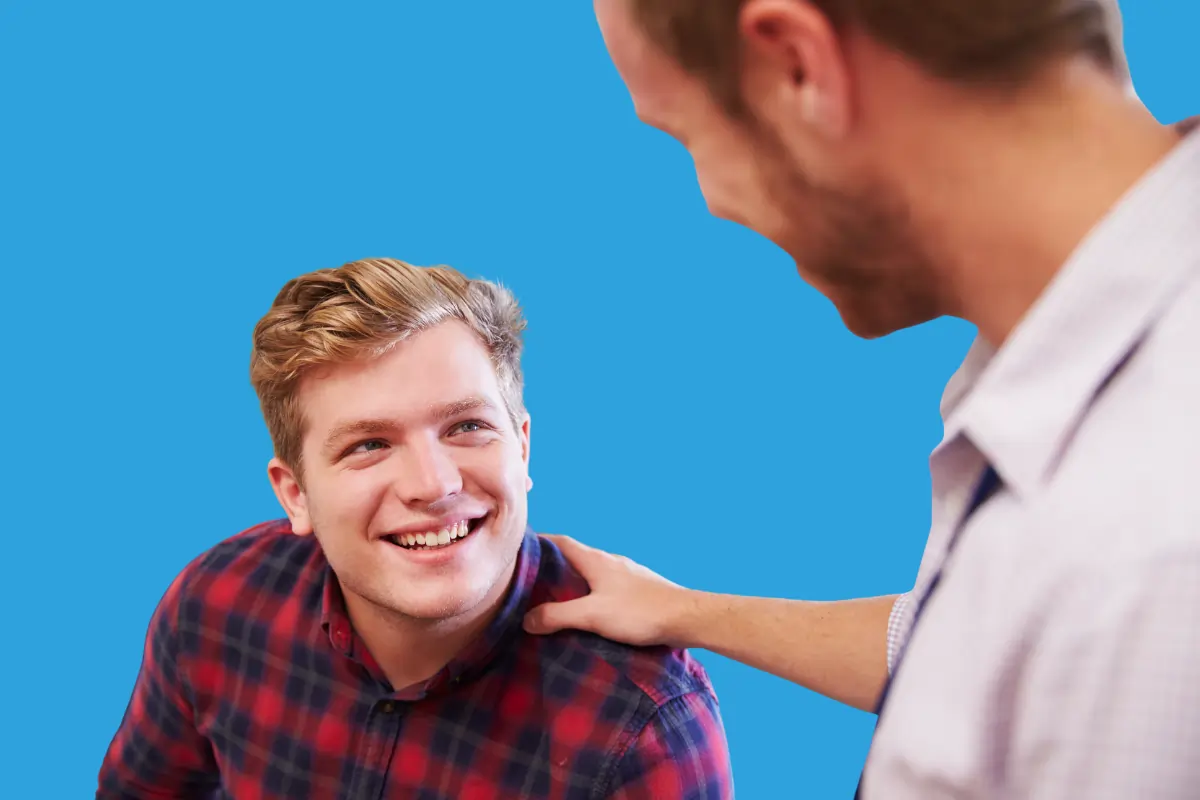 une homme qui pose sa main sur l'épaule d'un autre homme pour le rassurer